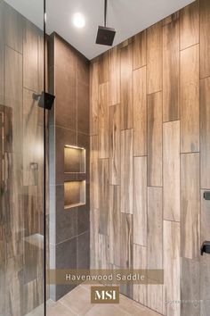 a walk in shower sitting next to a wooden wall with lights on it's sides