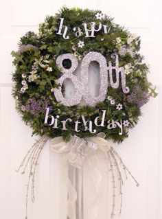 a wreath with the number eightyth birthday written on it is hanging on a door