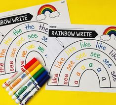 two rainbow writing worksheets with crayons next to them on a yellow background