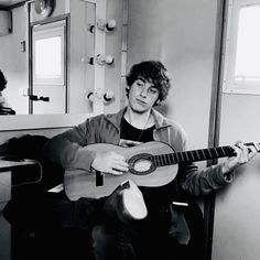 a man sitting in a chair holding a guitar