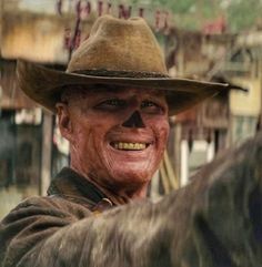 an old man wearing a cowboy hat and smiling