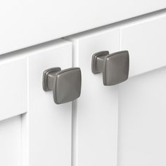 a close up of two handles on a white cabinet