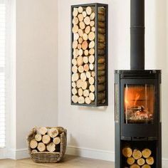 a wood burning stove in a living room next to a basket with logs on it