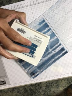 a person's hand on top of a piece of paper with barcodes