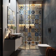 a bathroom with a glass shower door next to a white toilet and sink in it