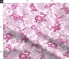 a pink and white fabric with rabbits on it