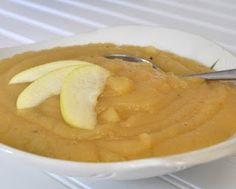 a white bowl filled with apples and oatmeal on top of a table