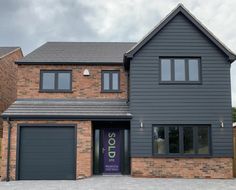 a two story brick house with garage doors and windows