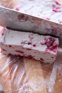 two pieces of cake sitting next to each other on top of plastic wrappers with a knife