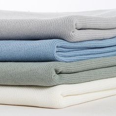 several folded blankets stacked on top of each other