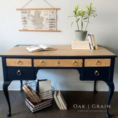 a blue desk with books and a plant on it next to a basket full of books