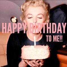 a woman is blowing out the candles on her birthday cake while sitting in front of an open suitcase