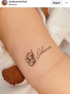 a small tattoo on the arm of a girl with a teddy bear and name written in cursive writing