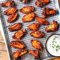 grilled chicken wings with ranch dressing on a baking sheet, ready to be served