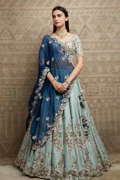 Jade lehenga in silk base with all over floral embroidery. Paired with embroidered blouse and blue dupatta.
Components: 3
Pattern: Embroidered
Type Of Work: Floral
Neckline: Round
Sleeve Type: Half
Fabric: Lehenga and Blouse: Silk, Dupatta: Organza
Color: Green, Blue
Other Details: 
Floral embroidery
Tassel details
Scallop hem dupatta
Occasion: Wedding - Aza Fashions Green Floral Lehenga, Orang India, Ghaghra Choli, Pengantin India, Simple Lehenga, Half Saree Lehenga, Georgette Lehenga, Indian Outfits Lehenga, Wedding Lehenga Designs