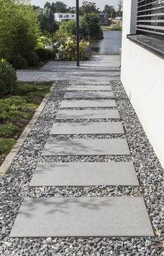 a walkway made out of stones next to a building