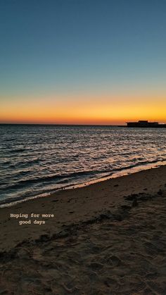 the sun is setting over the ocean with a boat in the distance