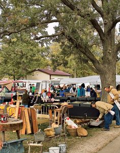 an outdoor flea market with people shopping and selling items