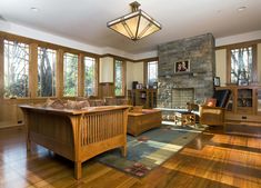 a living room filled with furniture and a fire place in front of a stone fireplace