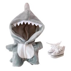 a stuffed shark is next to a pair of shoes and a slip on sneaker