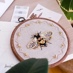 a close up of a bee on a piece of cloth with gold trimmings