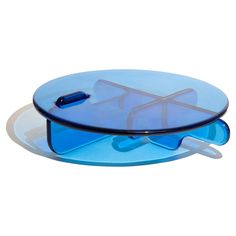 a blue glass tray with two pieces of plastic on top and one piece of plastic in the middle