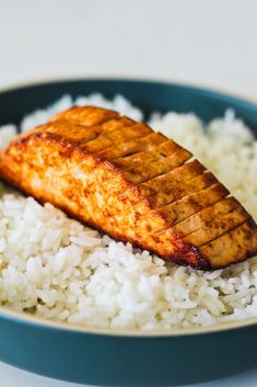 a plate with white rice and salmon on it, ready to be eaten or served