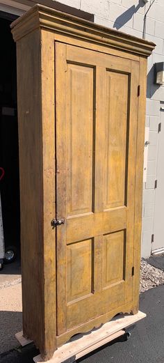 an old wooden armoire sitting in front of a building