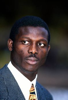 a man in a suit and tie looking at the camera with an intense look on his face