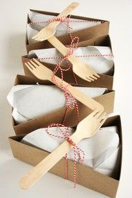 three cardboard boxes with forks and napkins in them, tied to wooden utensils