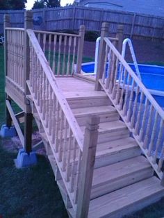 a wooden deck next to an above ground swimming pool with railings and handrails