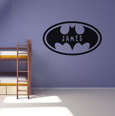 a bedroom with a bunk bed and batman wall decal