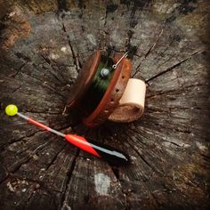 a piece of wood that has some sort of object on top of it, including a spool of thread and a toothbrush