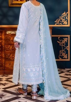 Introducing our New collection 'FASANA-E-ISHQ EID LUXURY LAWN COLLECTION' by Asim Jofa designed to make you look and feel your best. Embrace the glimmers of frost with this captivating ice blue attire adorned with intricate white and self-colored threadwork and shimmering silver 3mm sequins. Like stars in a winter sky, the neckline and borders shimmer with luxurious 9mm sequins casting a spell of enchantment. With embroidered details on the neckline, borders and sleeves, this ensemble captures the essence of frosty elegance. The embroidered border for the hemline and chaak adds a touch of winter magic while the embroidered dupatta with four-side border drapes you in the glimmers of frost. Embroidered Neckline For Front. Embroidered Front With Thin Border On Lawn. Embroidered Neckline For B Light Blue Georgette Dress For Eid, Festive Light Blue Dresses With Mirror Work, Light Blue Fitted Dress With Mirror Work, Fitted Light Blue Dress For Eid, Festive Light Blue Dress For Eid, Elegant Light Blue Dresses With Dabka Work, Elegant Light Blue Dress With Dupatta, Velvet Anarkali, Organza Kurti