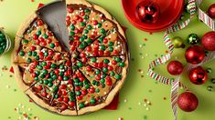 there is a pizza with many toppings on the table next to christmas ornaments and decorations