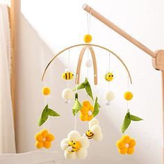 a baby crib mobile with flowers and bees hanging from it