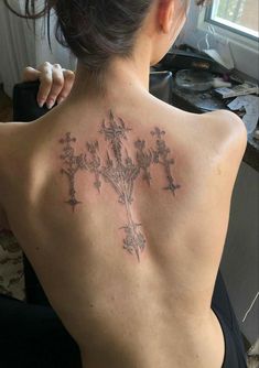 a woman with a cross tattoo on her back