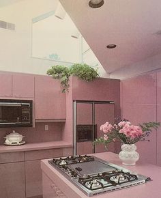 a pink kitchen with an oven, stove and microwave in it's center island