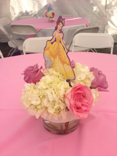 a vase filled with flowers on top of a pink table covered in white and pink napkins