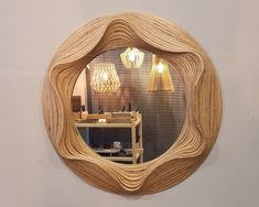 a circular mirror hanging on the side of a wall next to a table and lamp