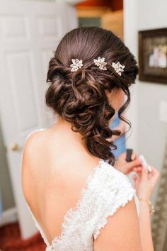 a woman in a wedding dress is brushing her hair with an electric toothbrush while looking at herself in the mirror