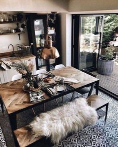 a dining room table with some chairs and a rug on the floor in front of it