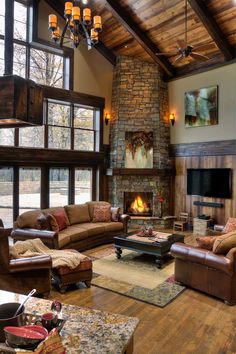 a living room filled with furniture and a fire place in the middle of a room