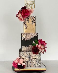 a three tiered cake decorated with flowers and the number seventy on it's side