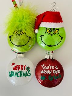 two christmas ornaments with grin the cat and you're a mean one