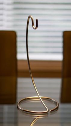 a close up of a metal object on a table with chairs in the back ground