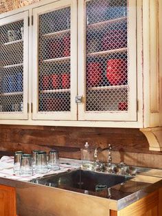 a kitchen with wooden cabinets and glass doors