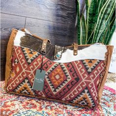 This Weekender Bag Is Absolute Perfection! How Adorable Is This Berry + Cowhide Weekender Bag?! The Front Features An Aztec Pattern With Colors Of Berry, Rust, Cream, & Black! The Top Features A Gorgeous Cowhide With A Flap & A Turquoise Concho! The Back Of This Bag Is A Brown Canvas With A Small Zipper Pouch. The Dark Brown Straps Are The Perfect Detail!! Inside The Zipper Opening There Is One Zipper Pouch & 2 Open Pouches To Keep All Of Your Things Organized! This Bag Is The Perfect Size For A Weekend Getaway!! Width: 19" Depth: 8" Height: 13" Handle: 12" Southern Roots Boutique 112 W Main St, Paragould, Ar Myra Weekender Bag, Red Shoulder Travel Bag For Everyday Use, Red Tote Travel Bag For Everyday Use, Red Satchel Weekender Bag, Red Satchel Weekender Bag For Everyday Use, Multicolor Leather Tote Weekender Bag, Multicolor Leather Weekender Tote Bag, Red Weekender Bag With Leather Handles For Everyday, Red Tote Weekender Bag For Everyday Use