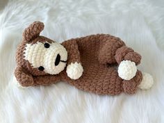 a crocheted stuffed animal laying on top of a white blanket