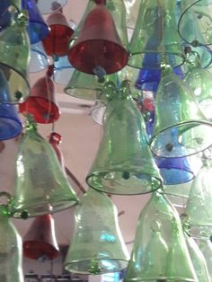 many different colored glass bells hanging from the ceiling